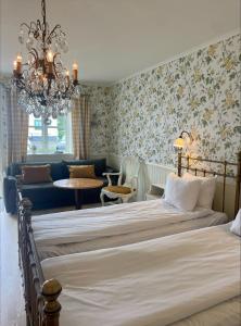 a bedroom with a bed and a chandelier at Hotel Slottsgården in Vadstena