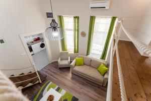 sala de estar con cortinas verdes y sofá en Downtown Greenie Home en Budapest