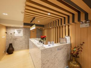 a lobby with a counter with flowers in a room at Watergate City in Bangkok