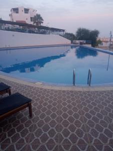 a large blue swimming pool with a bench next to it at Studio cabo dream in Tetouan +8 photos