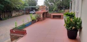 a patio with potted plants and a bench at 1010 Clifton bnb in Centurion