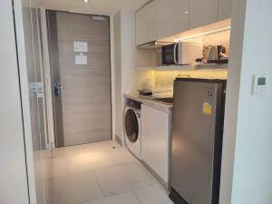 a small kitchen with a washing machine and a washer at Ashley Hotel BKK in Bangkok