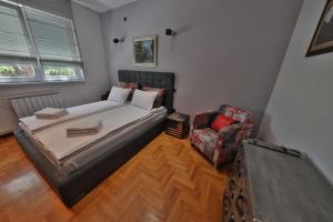 a bedroom with a bed and a chair at Premium apartment in Belgrade in Belgrade