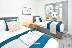 two beds in a room with a window at Ivory House by Truestays - 3 Bedroom House in Stoke-on-Trent in Etruria