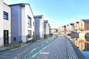 a row of houses next to a canal at Ivory House by Truestays - 3 Bedroom House in Stoke-on-Trent in Etruria