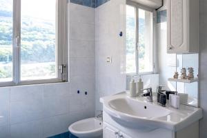a white bathroom with a sink and a toilet at Incantevole appartamento con parcheggio gratuito in Trento
