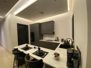 a kitchen with a sink and a counter with chairs at 3 - Bedroom Apartment in Riyadh