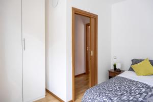 a bedroom with a bed and a mirror at Incantevole appartamento con parcheggio gratuito in Trento