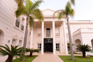 a white building with palm trees in front of it at THE WHITE PALACE Rabat in Rabat