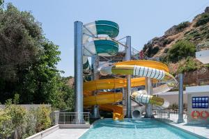 a water slide in a swimming pool at Porto Platanias Village Resort in Plataniás