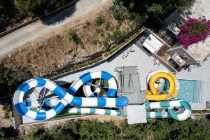 an overhead view of a water park with a pool and a large blue and white at Porto Platanias Village Resort in Plataniás