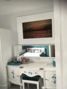 a bedroom with a desk with a bed in the background at Loggans Lodge in Hayle +17 photos
