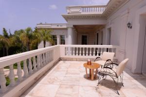 uma varanda de uma casa com uma mesa e cadeiras em THE WHITE PALACE Rabat em Rabat