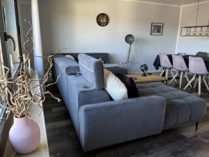 ein Wohnzimmer mit einem blauen Sofa und einem Tisch in der Unterkunft Haus Blumenglück in Herscheid