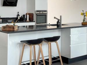 una cocina con dos taburetes negros en un mostrador en 12 person holiday home in Hadsund, en Nørre Hurup