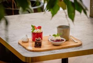 a tray with desserts and a cup on a table at Domaine des Dryades - Hôtel & Spa in Pouligny-Notre-Dame +60 photos