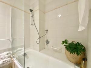 a white bathroom with a shower and a plant in it at CasaViva - Wonderful Bilo in Camogli in Camogli +11 photos