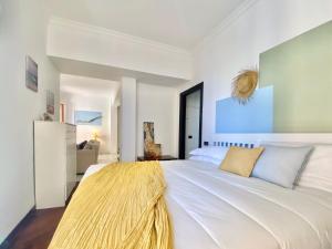 a bedroom with a large white bed with a yellow blanket on it at CasaViva - Wonderful Bilo in Camogli in Camogli