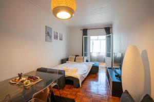 um quarto com uma cama e uma mesa em The Av. Roma Apartment em Lisboa