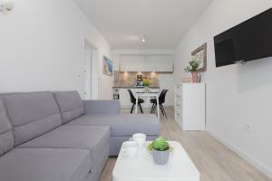 a living room with a couch and a table at Morska Apartment Dziwnówek by Noclegi Renters in Dziwnówek