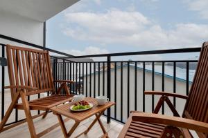 a balcony with two chairs and a bowl of fruit on a table at Morska Apartment Dziwnówek by Noclegi Renters in Dziwnówek