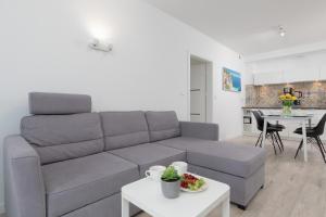 a living room with a couch and a table at Morska Apartment Dziwnówek by Noclegi Renters in Dziwnówek