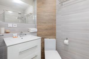 a white bathroom with a toilet and a sink at Morska Apartment Dziwnówek by Noclegi Renters in Dziwnówek +19 photos