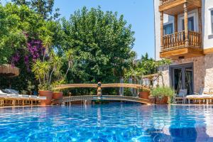 a swimming pool with a bridge and a fountain at Elixir Hotel in Kalkan