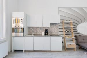 une cuisine avec des placards blancs et un escalier dans l'établissement Designer Apartment on the Budapest Broadway with 2BR and AC, à Budapest