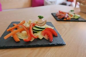 um prato de alimentos com legumes sobre uma mesa em All Suite Hotel Garni Leithner em Pertisau