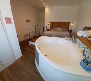 uma grande banheira num quarto com uma cama em B&B 106 Maison de Charme em Mola di Bari
