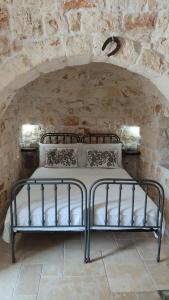 ein Schlafzimmer mit einem Bett in einer Steinmauer in der Unterkunft Trullo Titti in Ostuni
