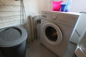 uma máquina de lavar roupa na casa de banho com um caixote do lixo em Elma Stay Location LAlbatros em Saint-Pierre-dʼOléron