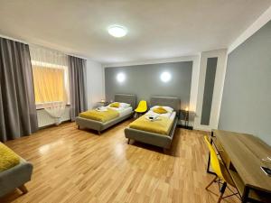 Sala de estar con 2 camas y mesa en Great Polonia Strzegom City Center, en Strzegom