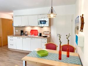 kuchnia ze stołem i zieloną miską w obiekcie Ferienanlage Kap Arkona - Appartement 22 w mieście Putgarten