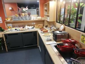 a kitchen that has a lot of food on the counter at Apparthotel Privilodges Carré de Jaude in Clermont-Ferrand
