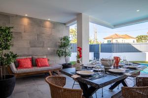 eine Terrasse mit einem Tisch, Stühlen und roten Kissen in der Unterkunft Villa Cuca in Aroeira