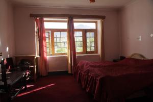 1 dormitorio con 2 camas y ventana en Hotel Dewachan, en Pituk