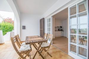 a dining room with a wooden table and chairs at Siesta Mar Originals in Cala'n Porter