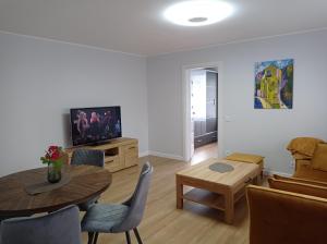 uma sala de estar com uma mesa e uma televisão em TIMO butas em Druskininkai