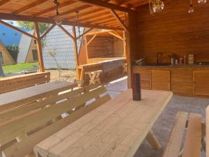 a wooden pavilion with benches and a kitchen in it at Vadu Cazare in Vadu