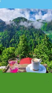 a cup of coffee and a glass of water on a table at Nanus Ayder Bungalow and Breakfast in Çamlıhemşin