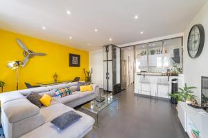 a living room with a white couch and a yellow wall at Super appartement au cœur de Nice! Bonnes vacances in Nice