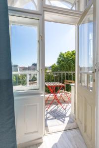 une chambre avec des portes et une table sur un balcon dans l'établissement Designer Apartment on the Budapest Broadway w 2BR, AC and Panorama Balcony, à Budapest