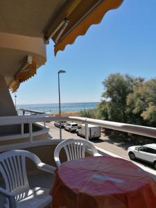 una mesa y sillas en un balcón con vistas al océano en Apartamentos Argonavis, en L'Estartit