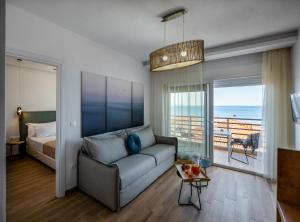 a living room with a couch and a bed at Aiora Suites in Psakoudia