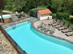 a swimming pool with lounge chairs and a swimming pool at Villa La casa del gat in Mosset