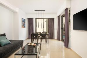 a living room with a couch and a table at Porto Platanias Beach Resort & Spa in Plataniás