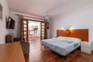 una camera da letto con un letto e un soggiorno con un tavolo di GO2TENERIFE Apart'Elisa Near the beach & Pool view a Playa de las Americas