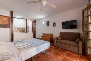 una camera da letto con un letto e un divano di GO2TENERIFE Apart'Elisa Near the beach & Pool view a Playa de las Americas